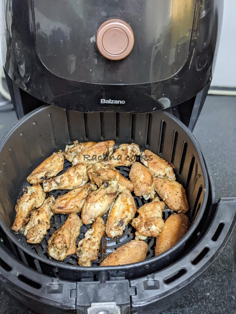 Chicken wings in air fryer basket after being air fried