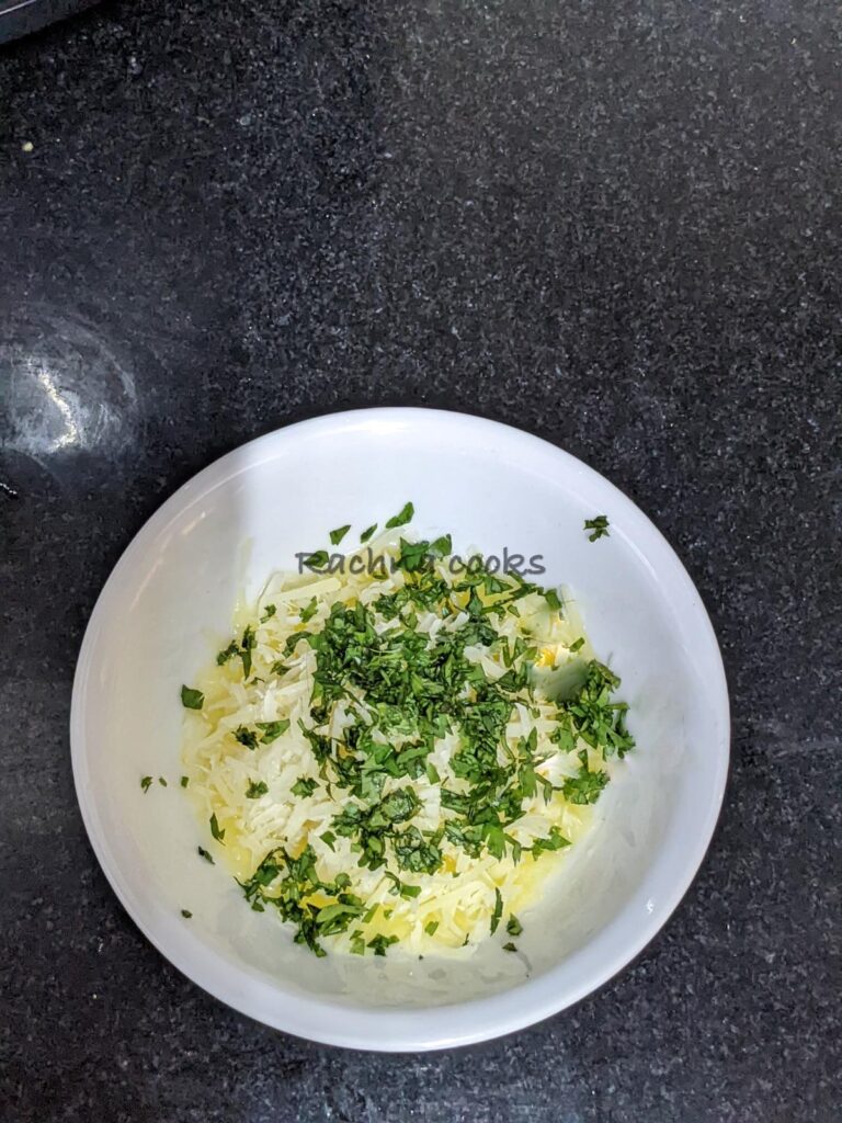 Grated parmesan in butter with chopped parsley in a white bowl