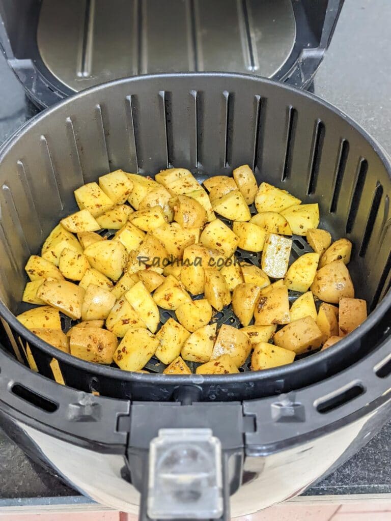 Potatoes in air fryer basket ready for air frying.