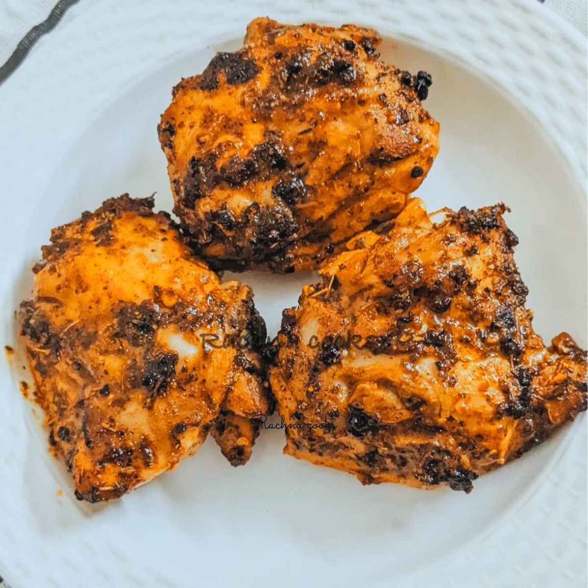 3 chicken thighs air fried on a plate.