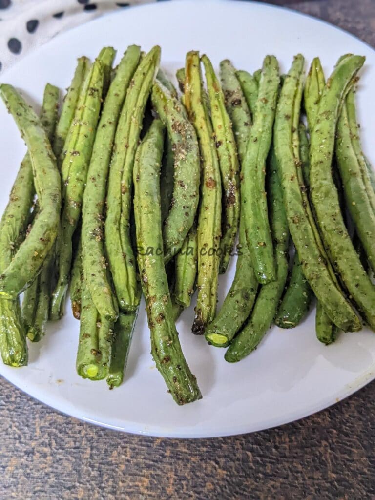 Close up of cooked green beans on a white plate