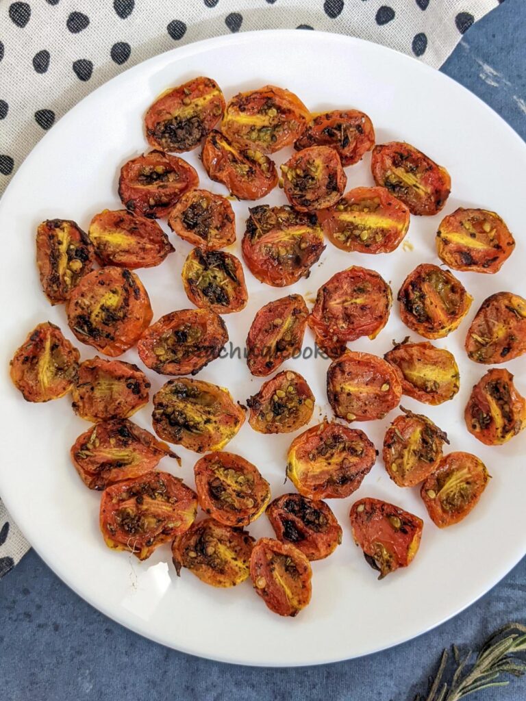 Air fried roasted cherry tomato halves on a white plate.
