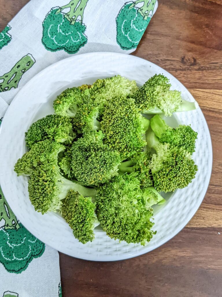 Steamed broccoli florets on a white plate