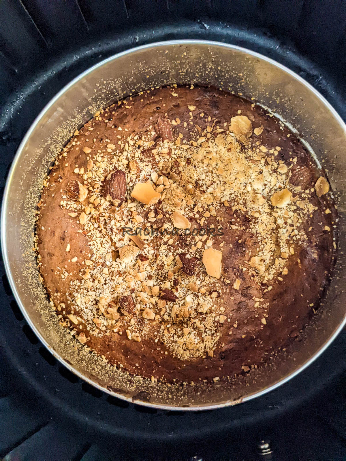 top shot of delicious banana bread in a cake tin garnished with nuts.