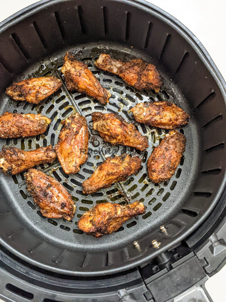 Chicken wings after air frying in air fryer basket.