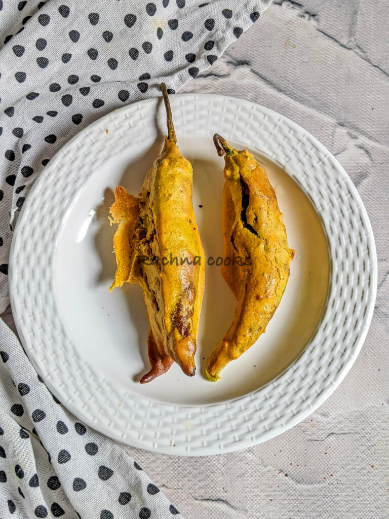 Two mirchi bhajjis air fried and on a white plate