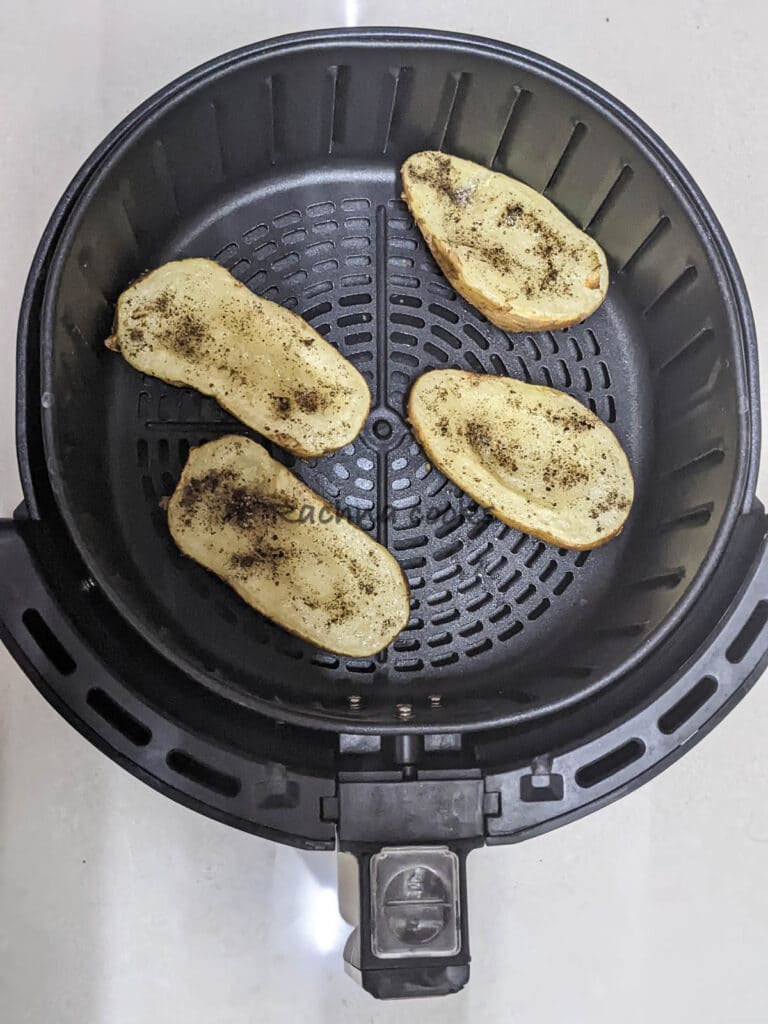 4 potato half boats in air fryer basket after air frying.