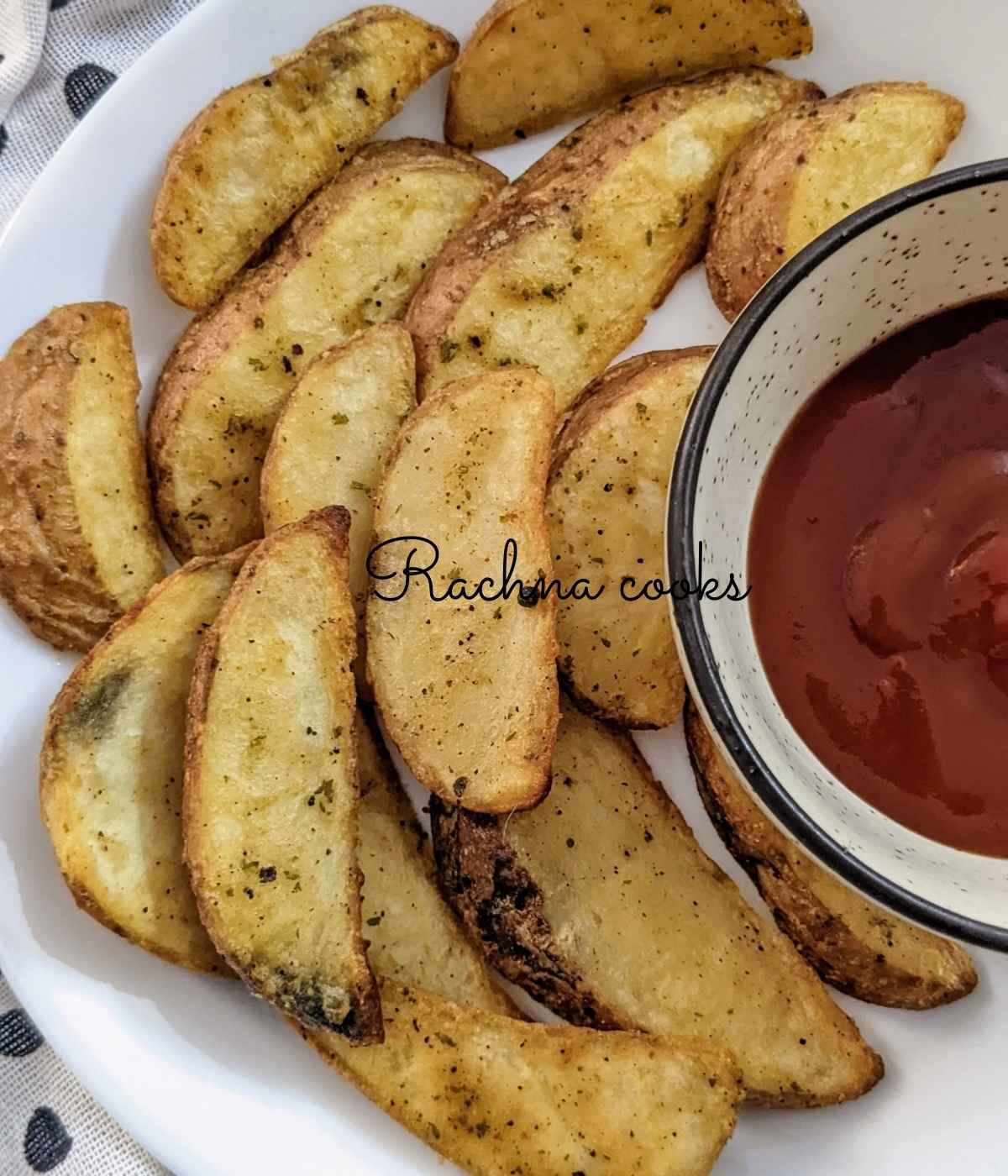 Frozen potato wedges after air frying on a white plate with ketchup in a bowl.