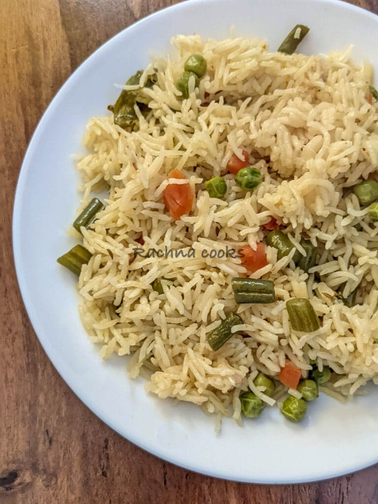 Close up of vegetable pulao on white plate.