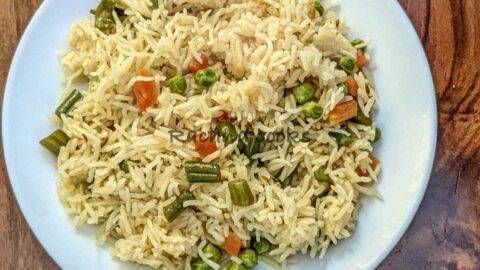 Top shot of vegetable pulao served in a white plate.