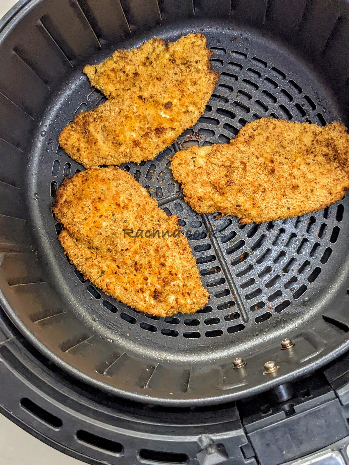 3 Chicken cutlets after air frying in air fryer basket.