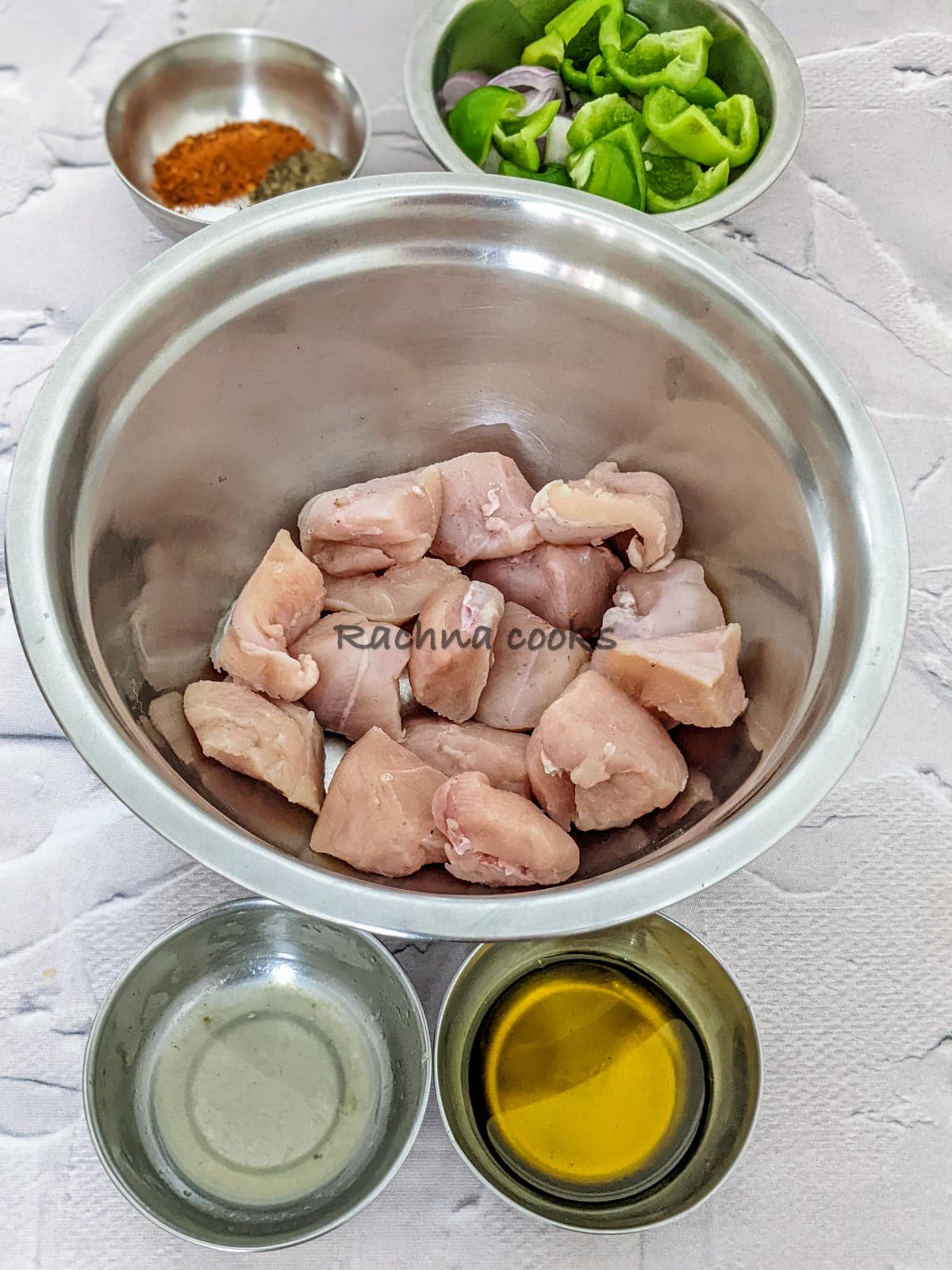Chicken cubes, oil. lemon juices, spices and cut pepper and onion in a bowl.