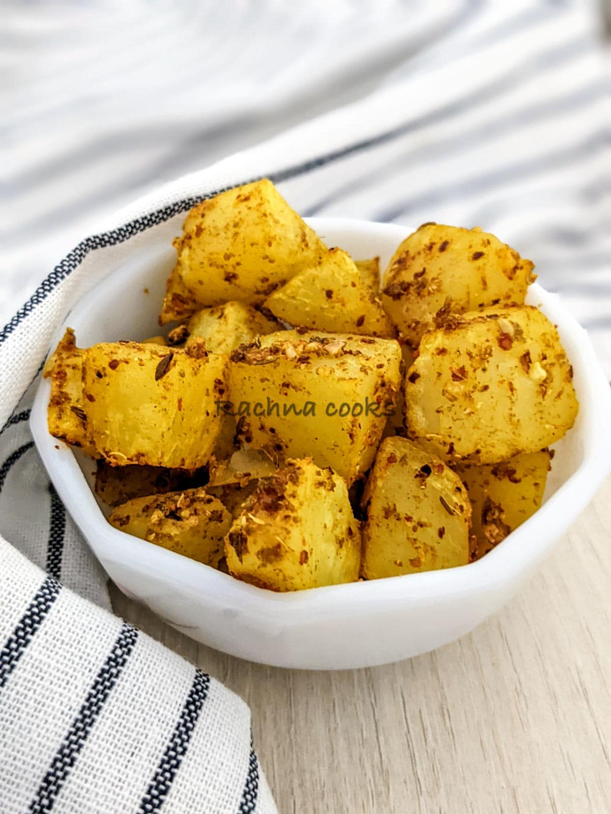 Air fried jeera aloo in a white bowl.