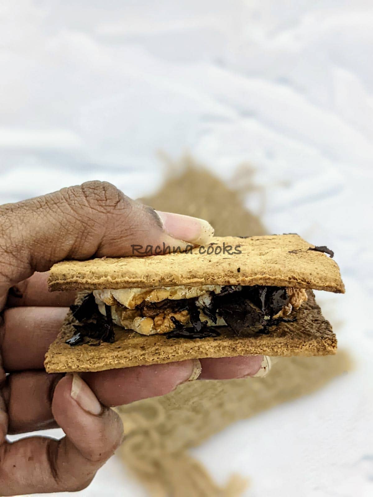 One s'more held up in hand.