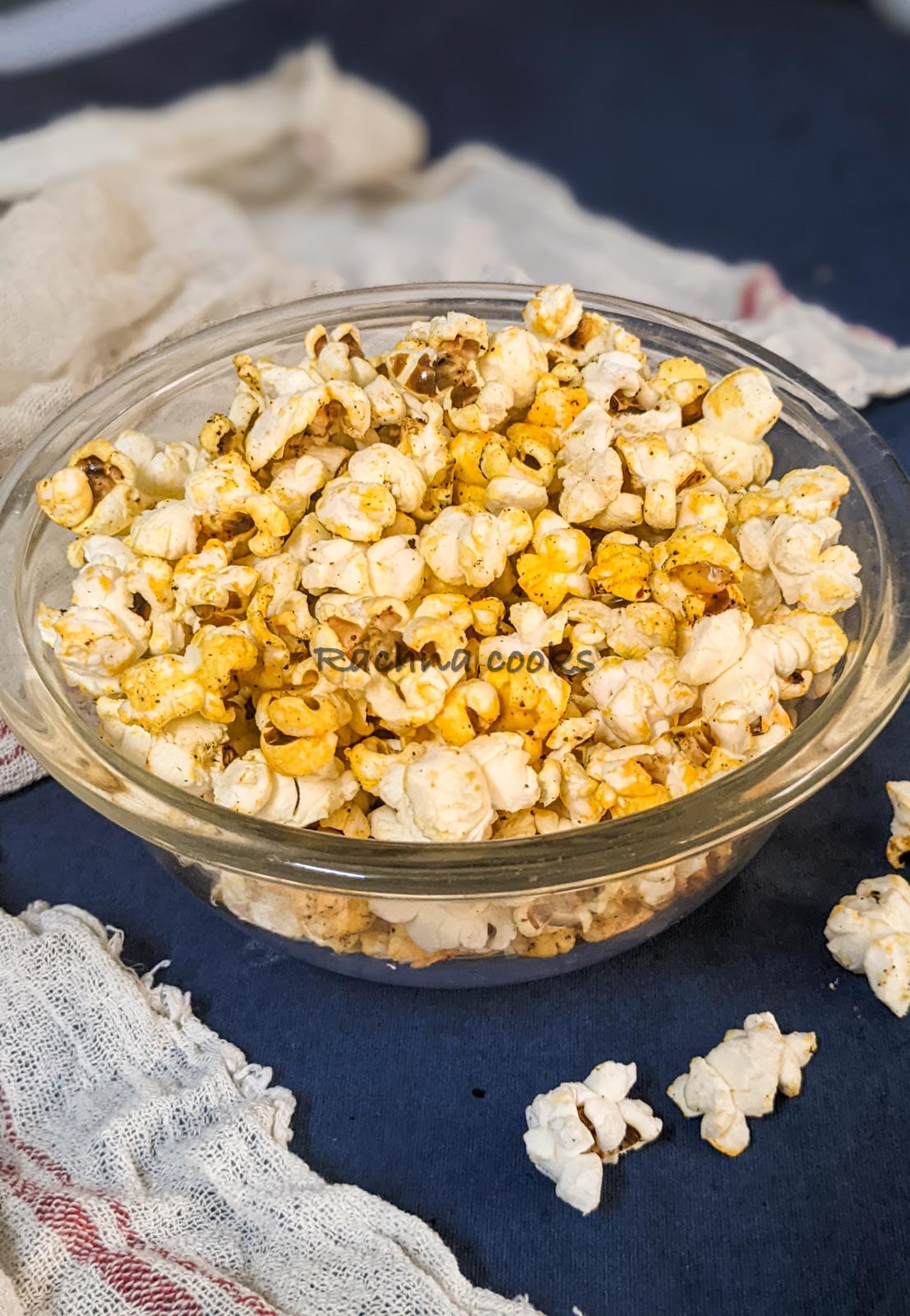 Shot of popcorn in a glass bowl with a blue background