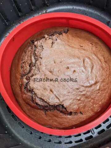 Delicious air fryer chocolate cake in a red mould in air fryer basket.
