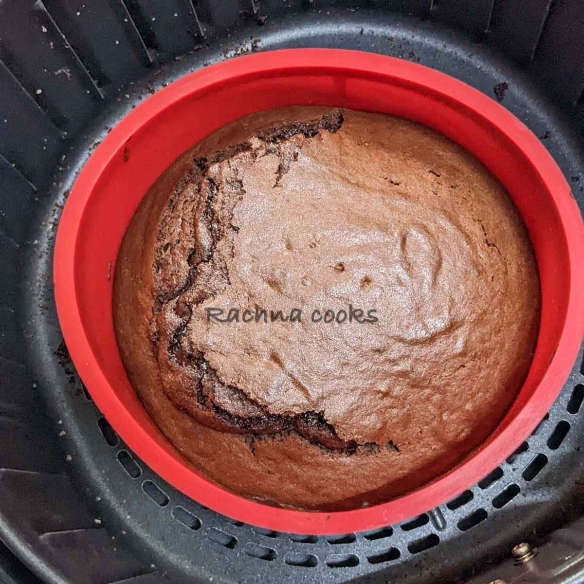 Delicious air fryer chocolate cake in a red mould in air fryer basket.