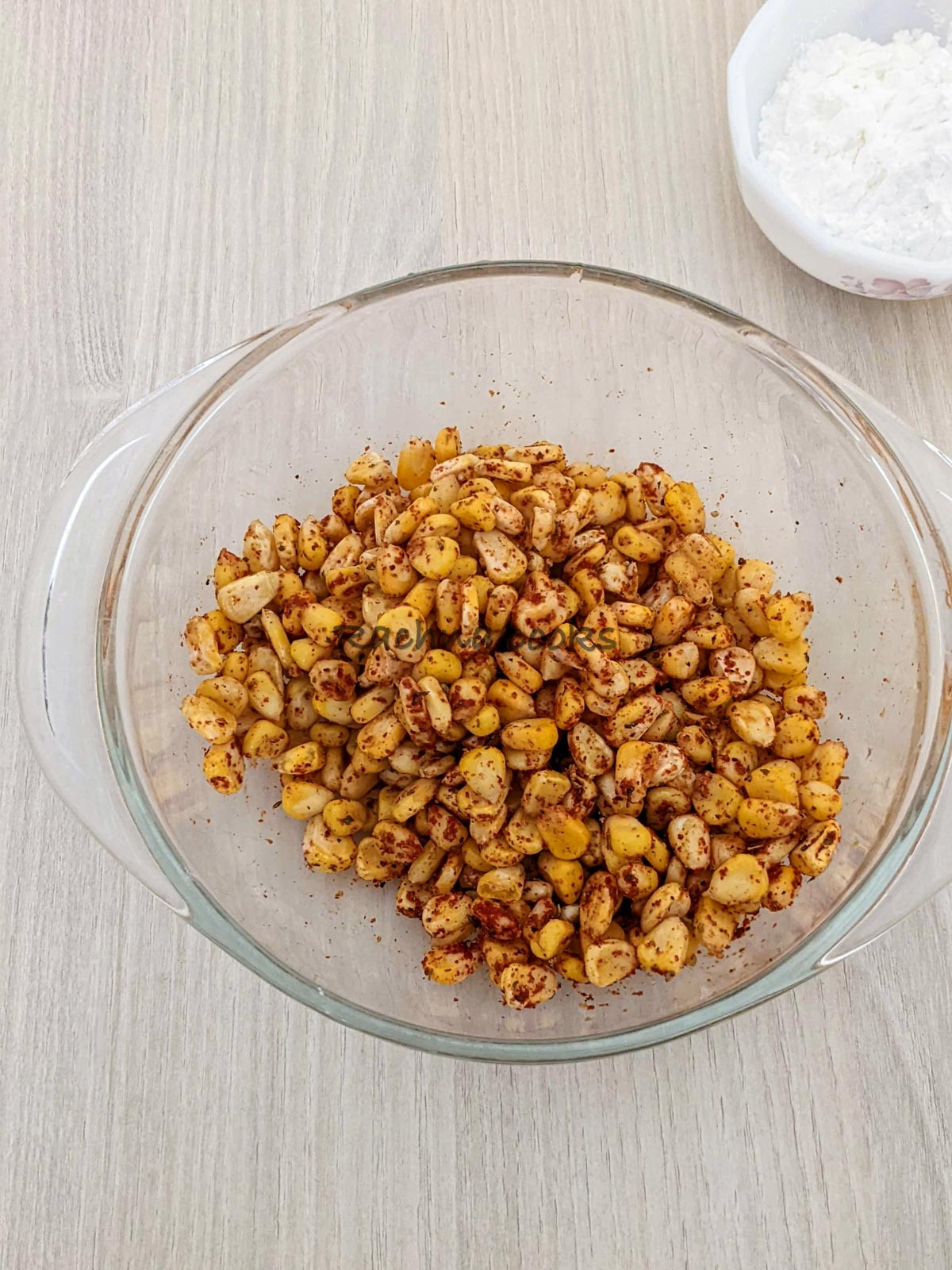 Sweet corn tossed with spices in a large bowl