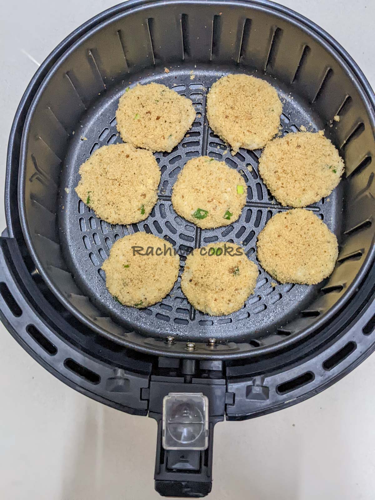 Potato pancakes in air fryer basket.