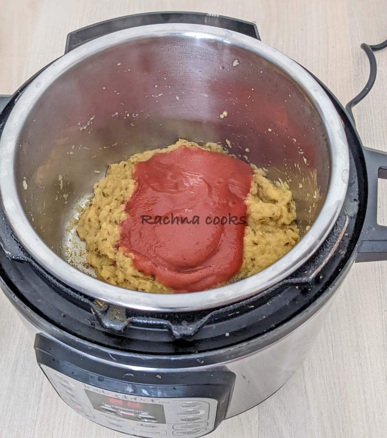 Instant pot with fried paste to which tomato paste is added.
