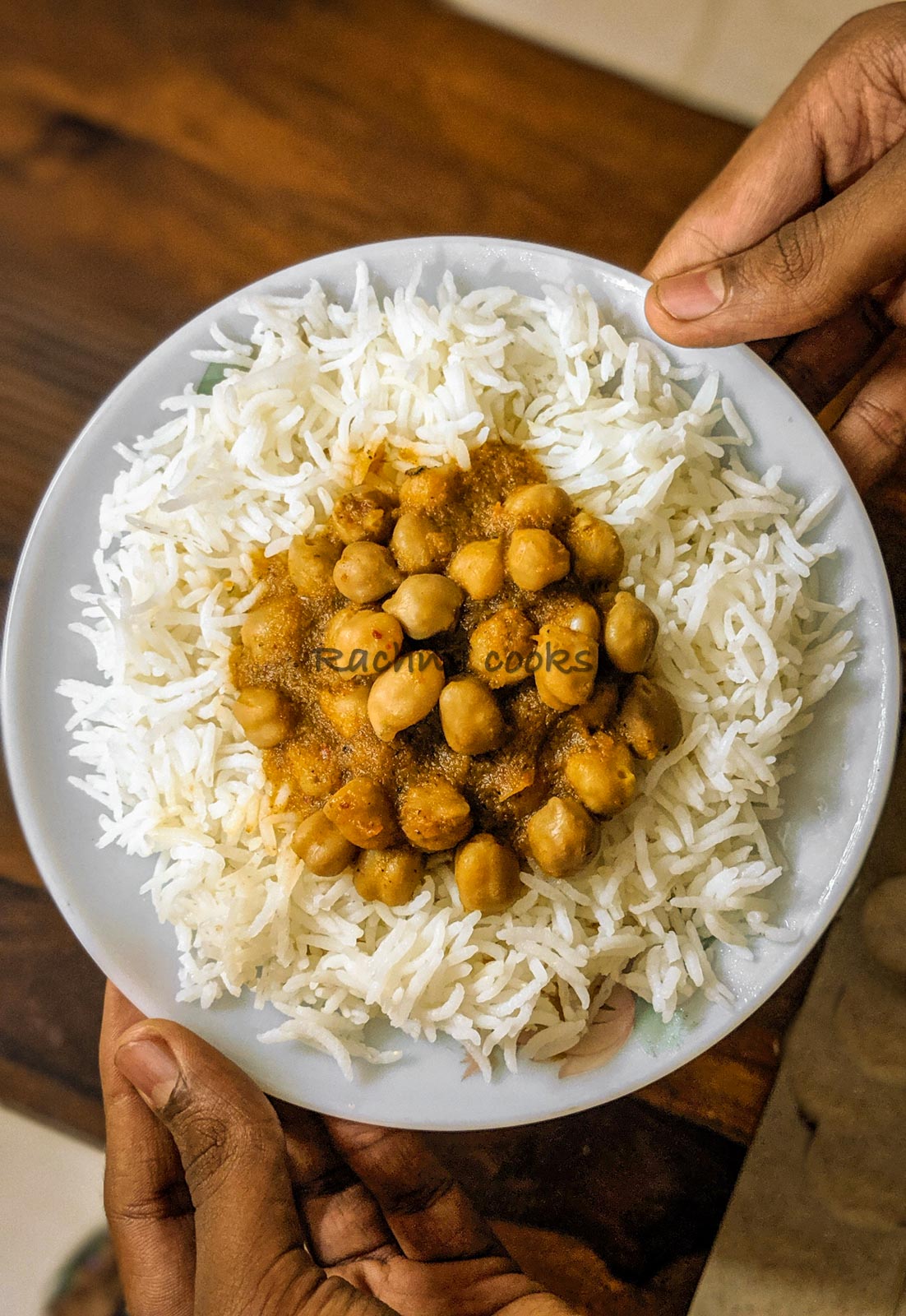 A plate with boiled basmati rice topped with chana masala curry