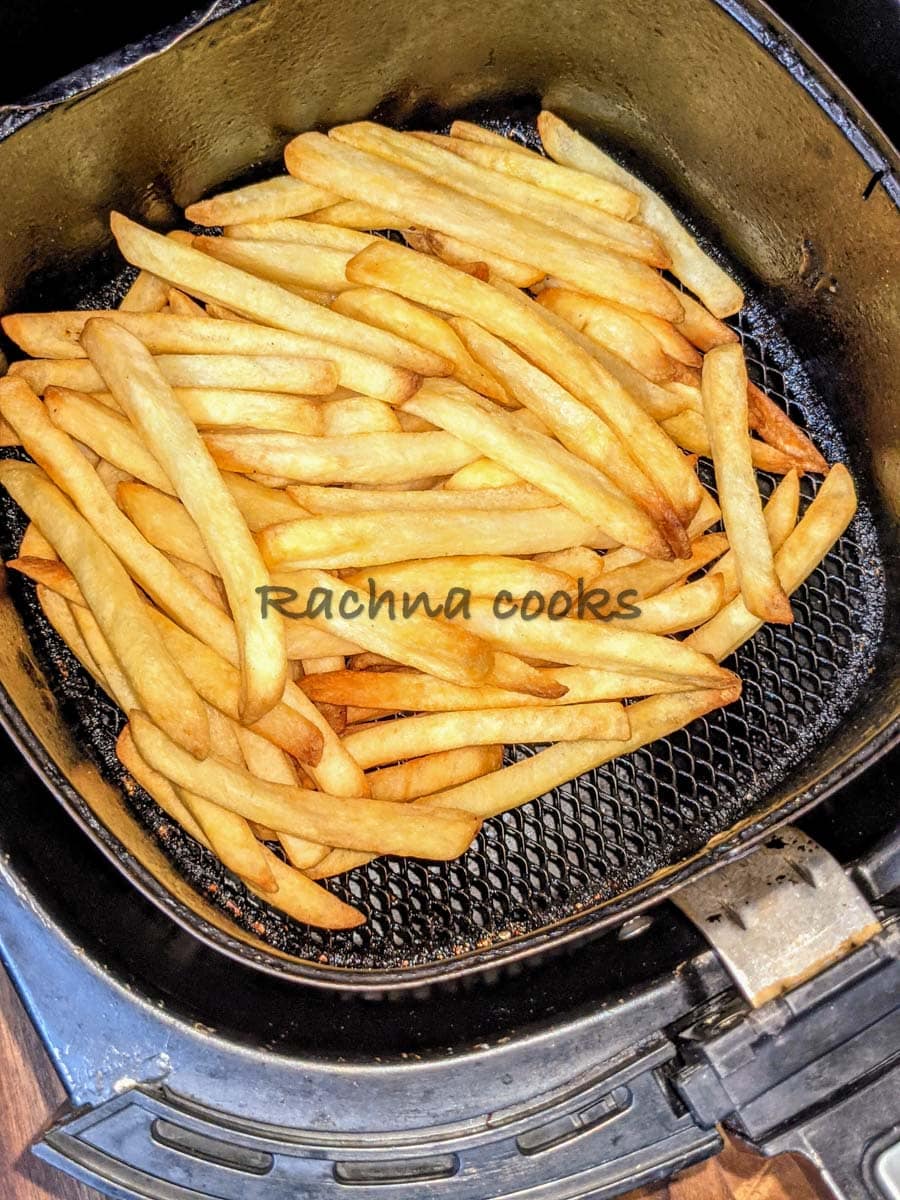 Fries after air frying in air fryer basket.
