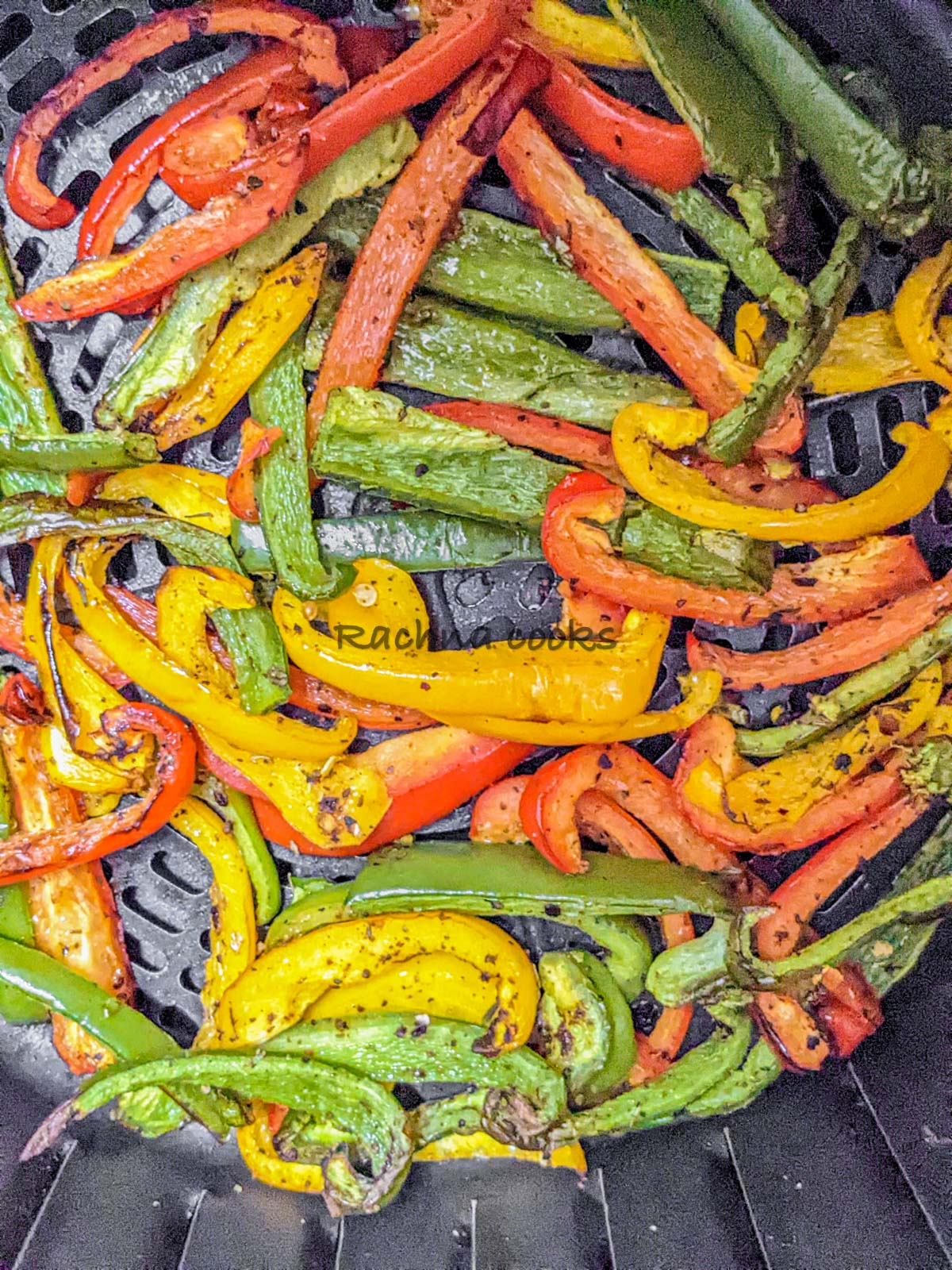 Close up of air fried peppers in air fryer basket.