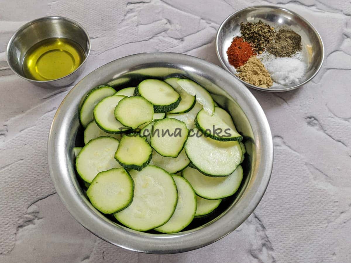 zucchini slices, olive oil and spices in 3 bowls.