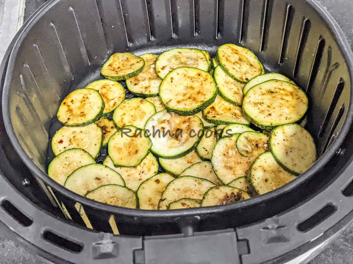 zucchini slices in air fryer ready for air frying.