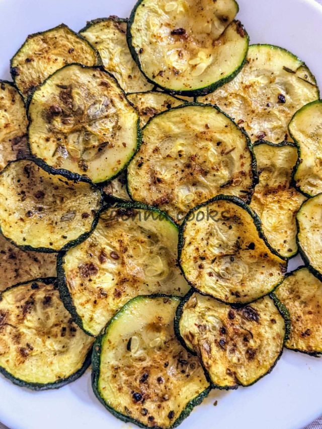 Close up of air fried zucchini chips on a white plate