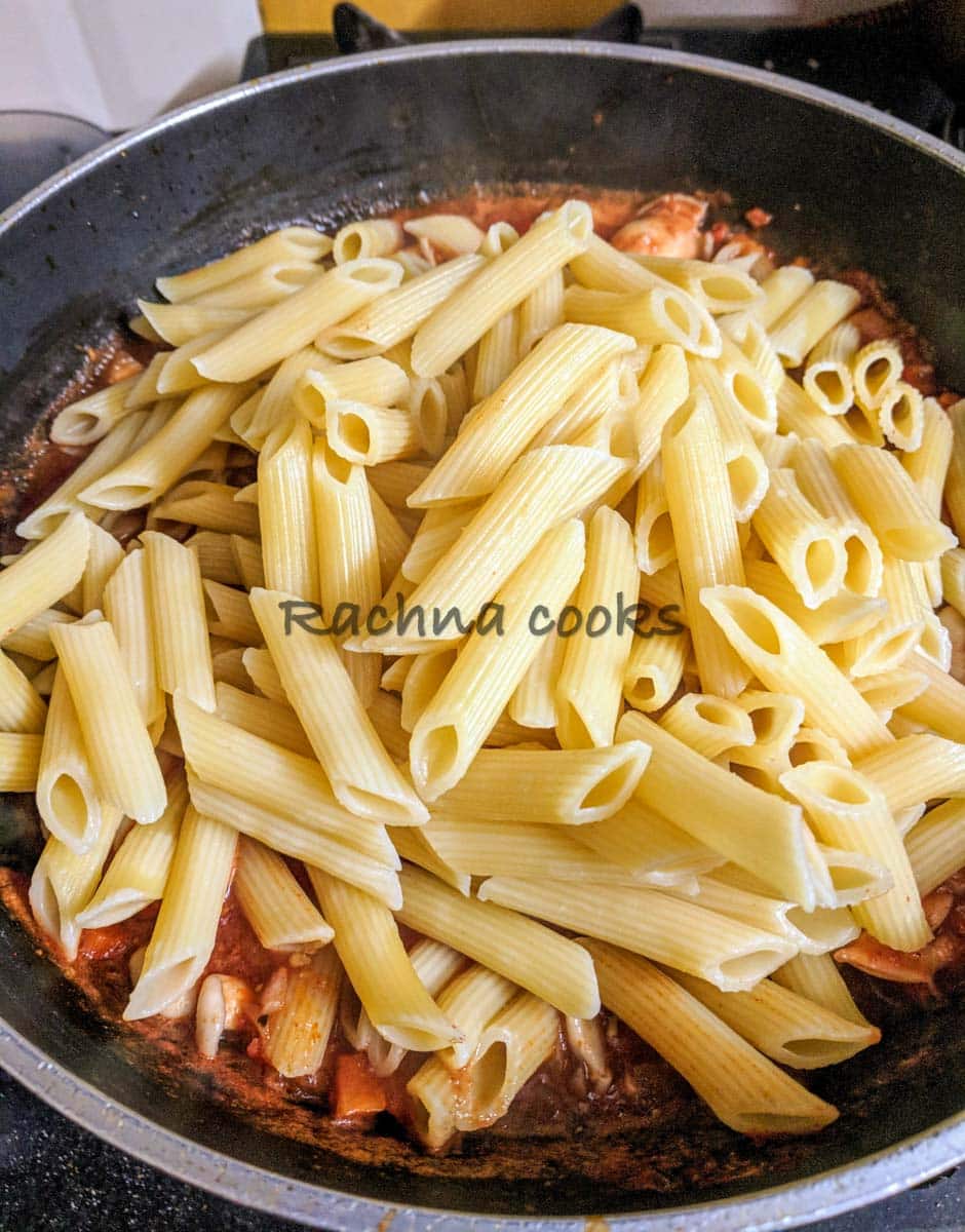 Boiled pasta tossed in tomato sauce.