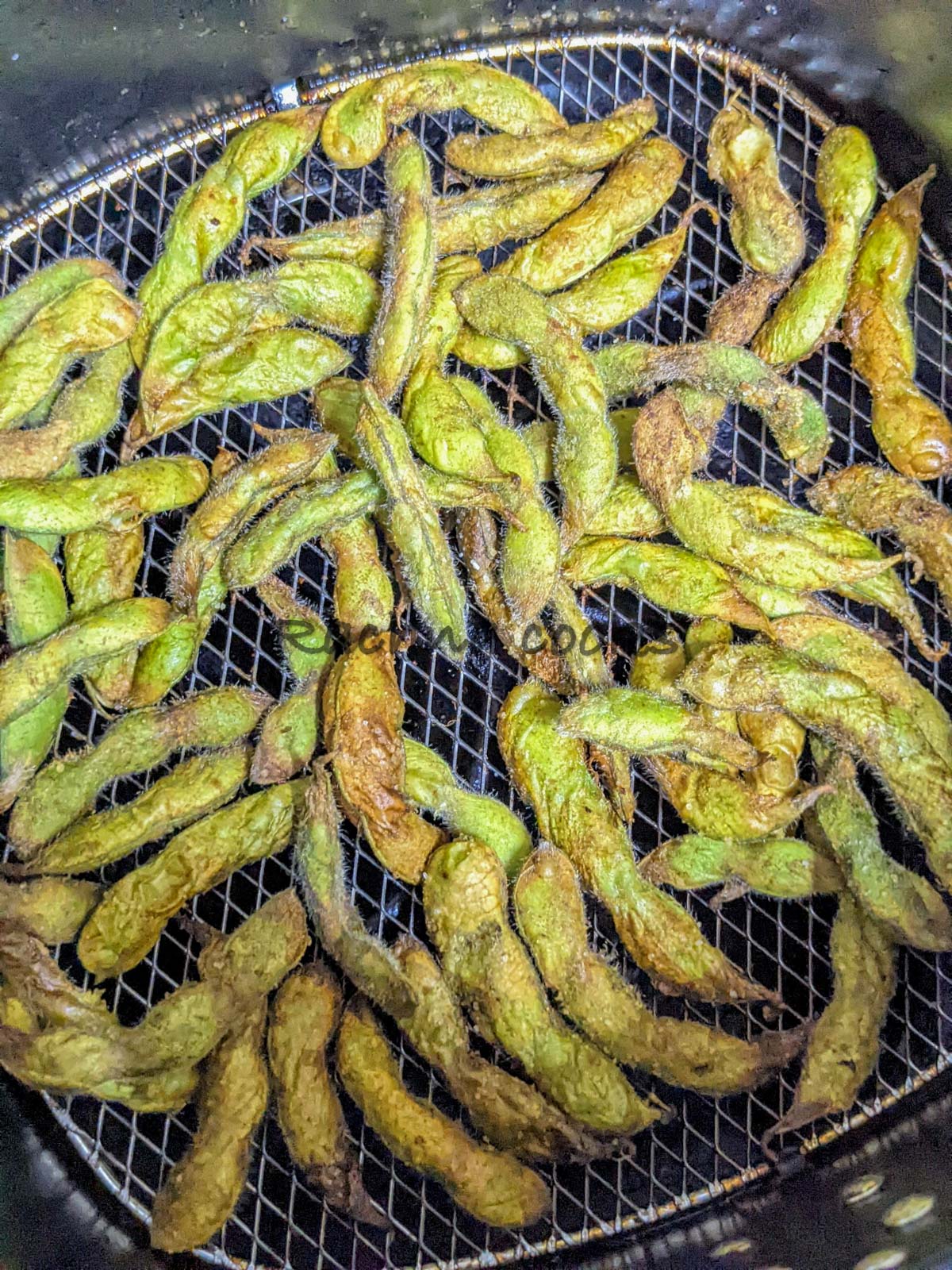 Close up of air fried edamame pods in air fryer basket