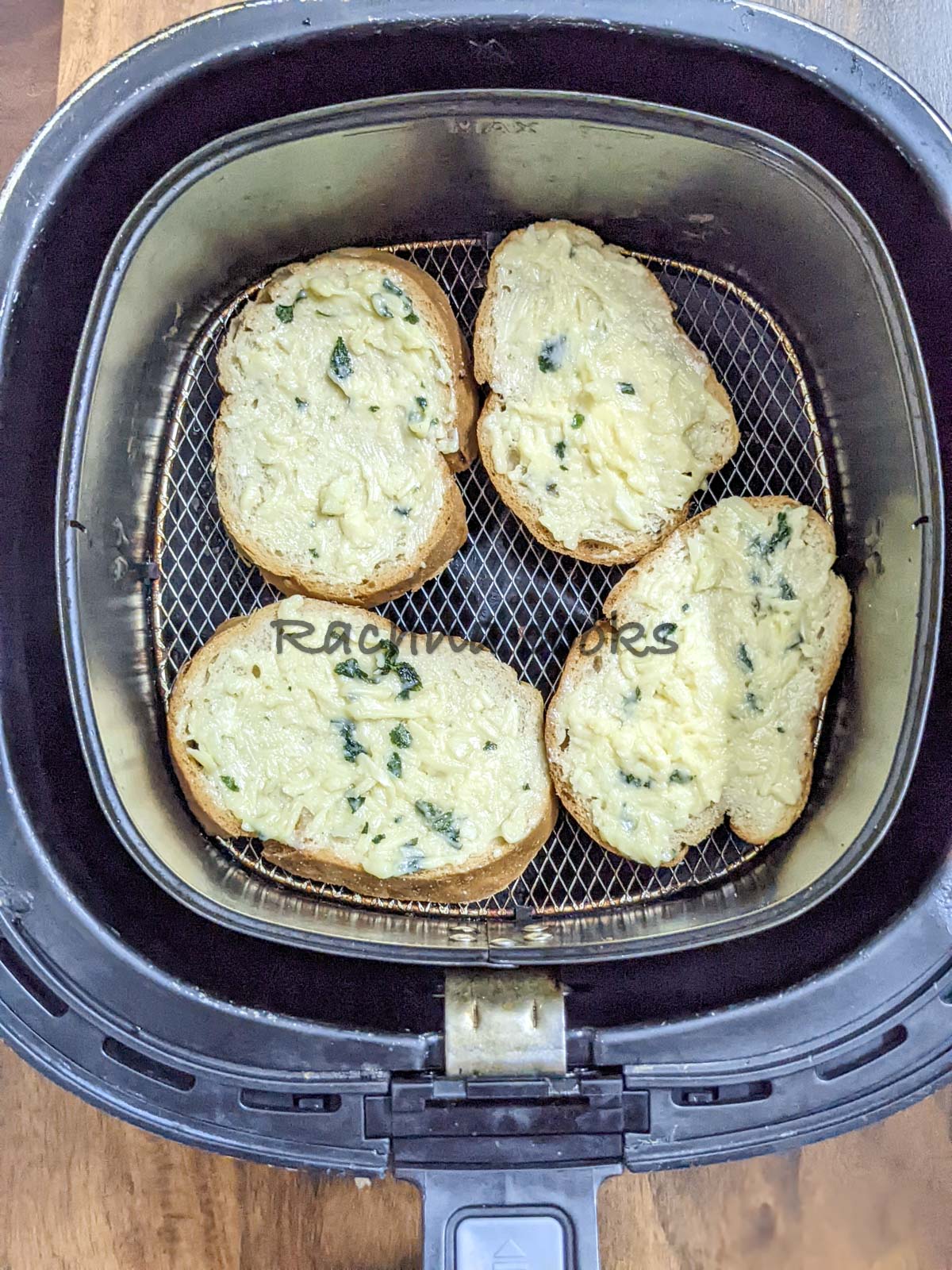 4 slices of garlic butter applied bread in air fryer basket.