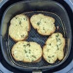 4 garlic bread slices after air frying in air fryer basket