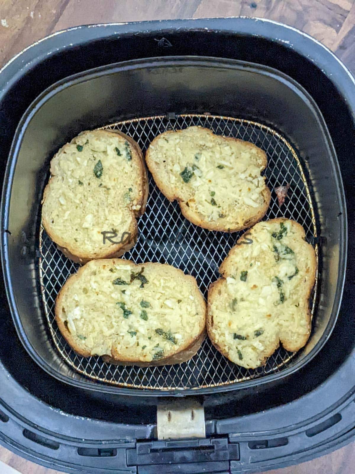 Toasty garlic bread after air frying in air fryer basket.