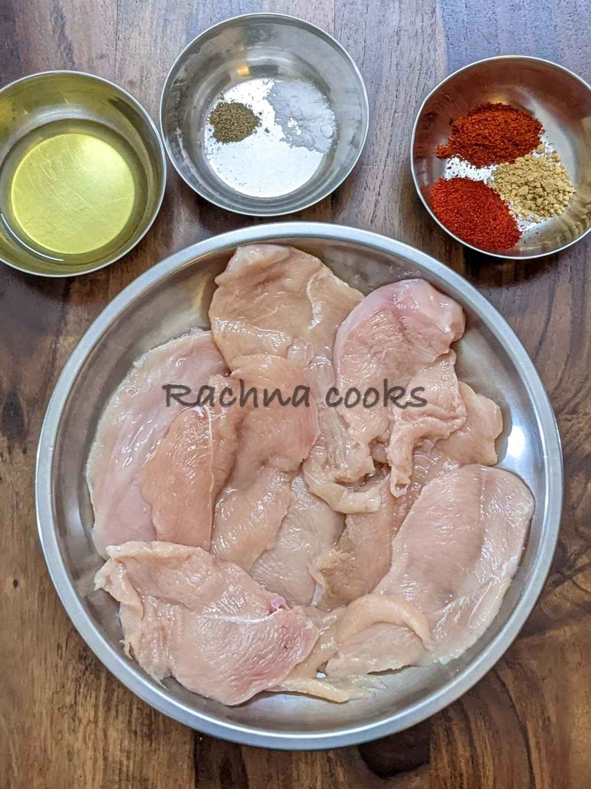 Ingredients for making BBQ chicken breast are assembled: chicken breasts, spices and olive oil in different bowls.