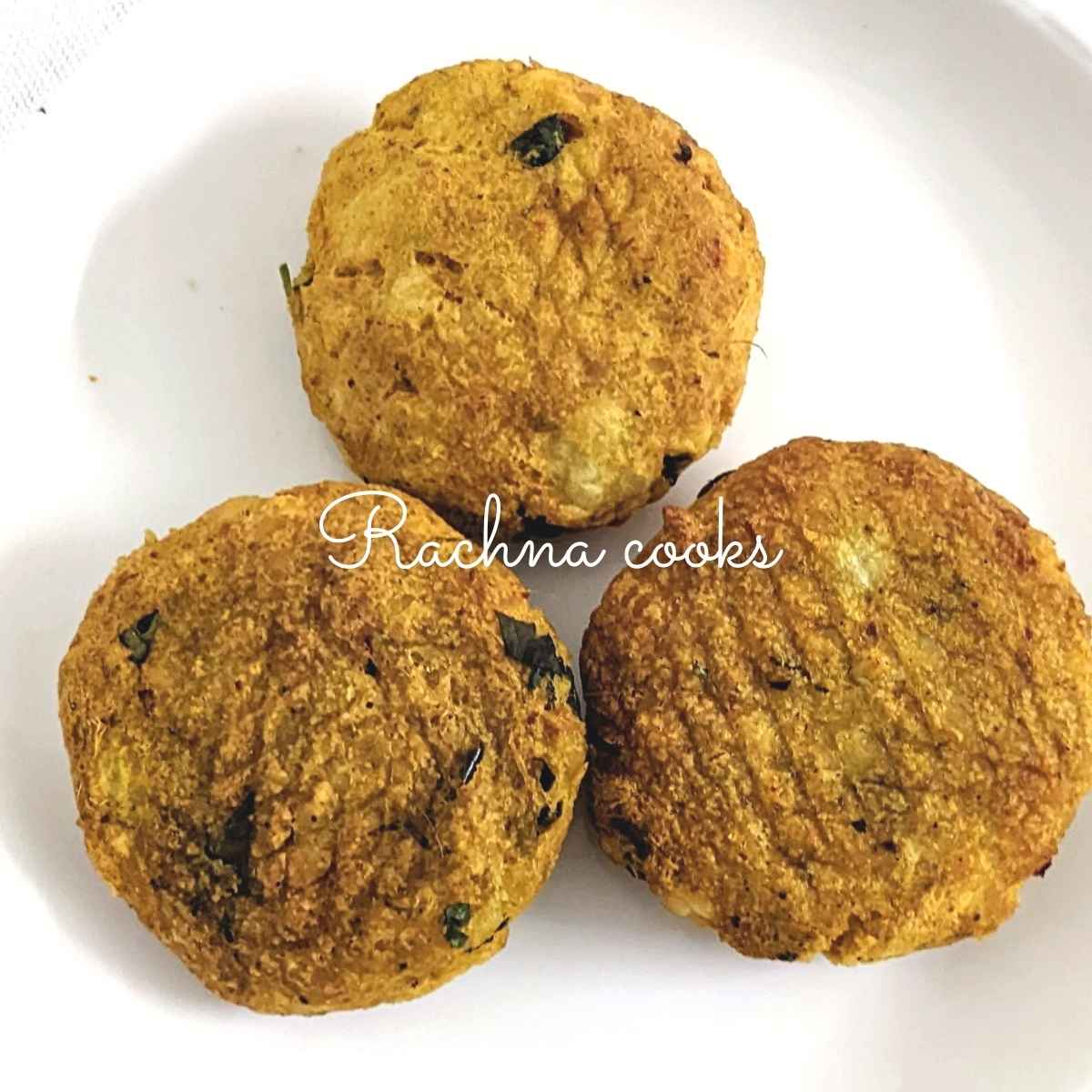 3 aloo tikkis on a white plate.