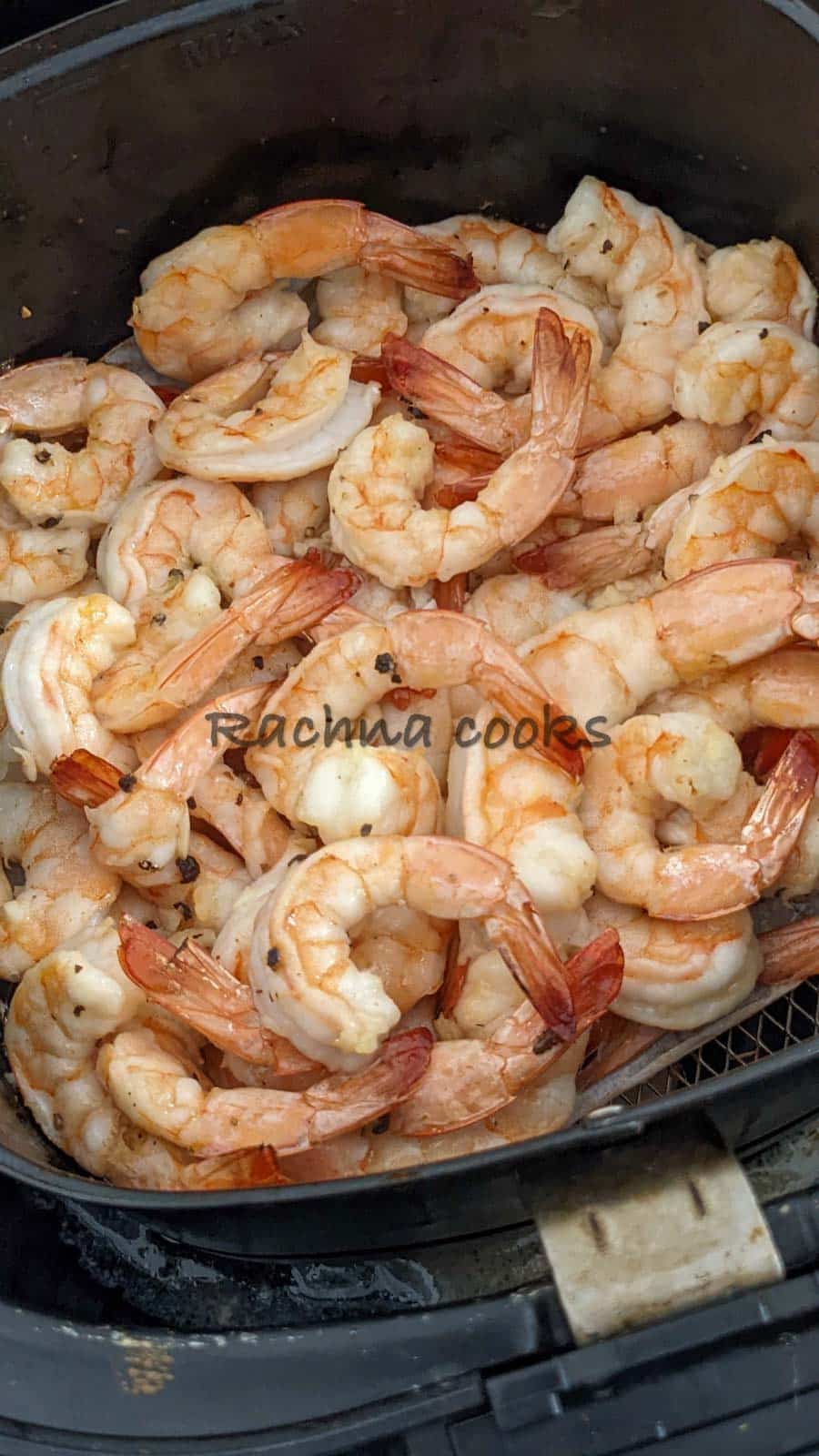 Close up of air fried shrimp in air fryer basket.