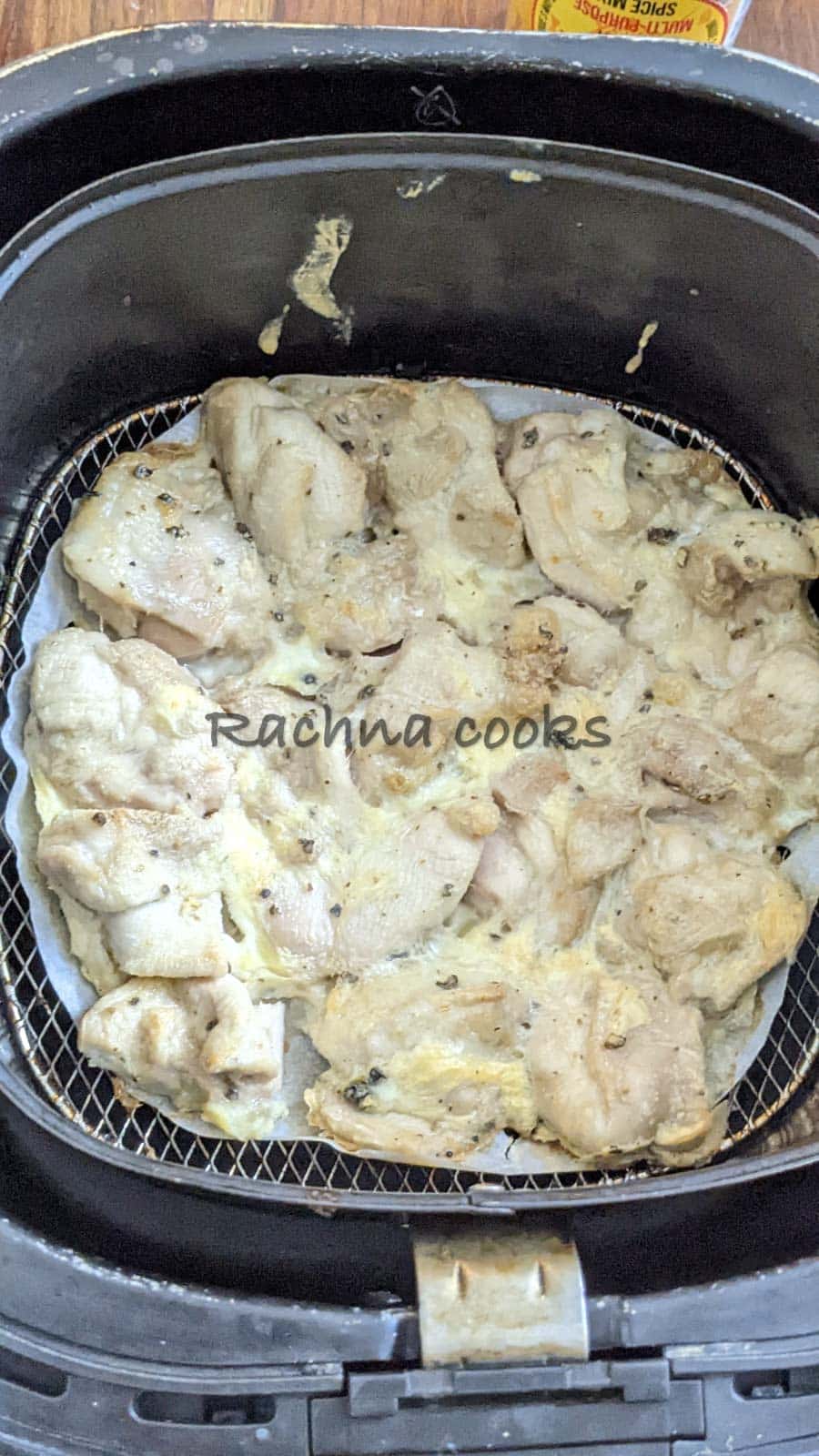 Chicken pieces after airfrying in air fryer basket.