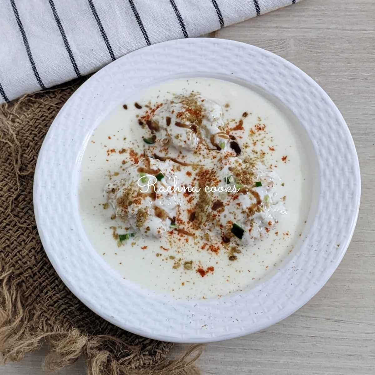 Dahi vadas served on a white plate.