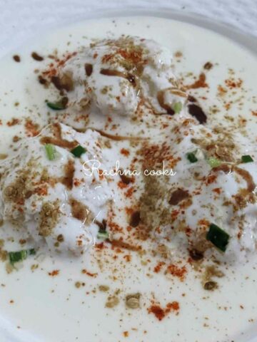 Close up of dahi vadas served on a plate.