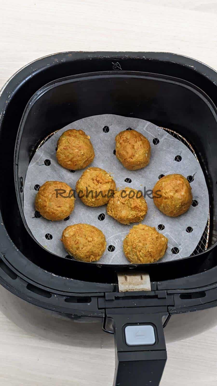 lauki kofte balls placed in air fryer basket for air frying.