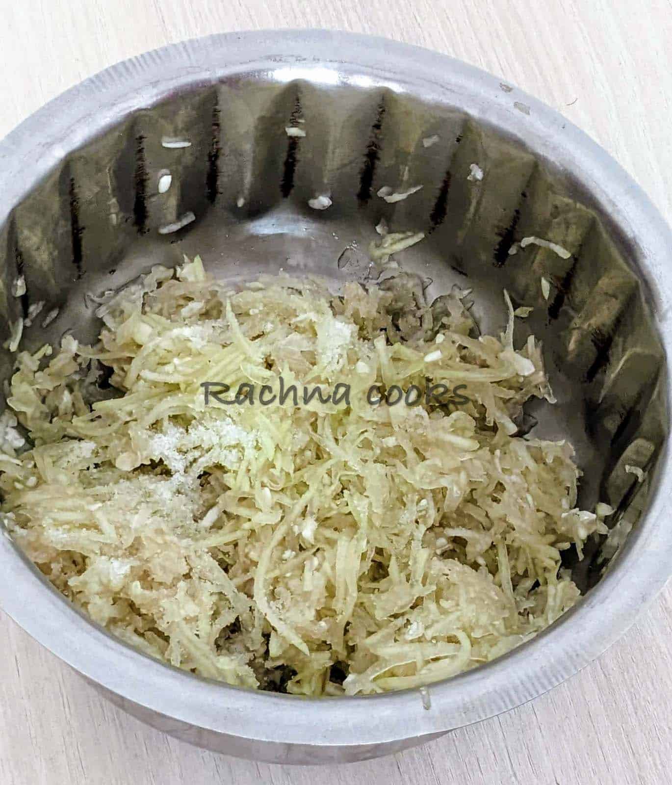 grated lauki in a bowl with added salt.
