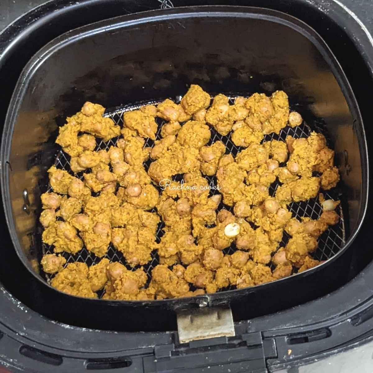 Coated peanuts placed in a single layer in air fryer basket.