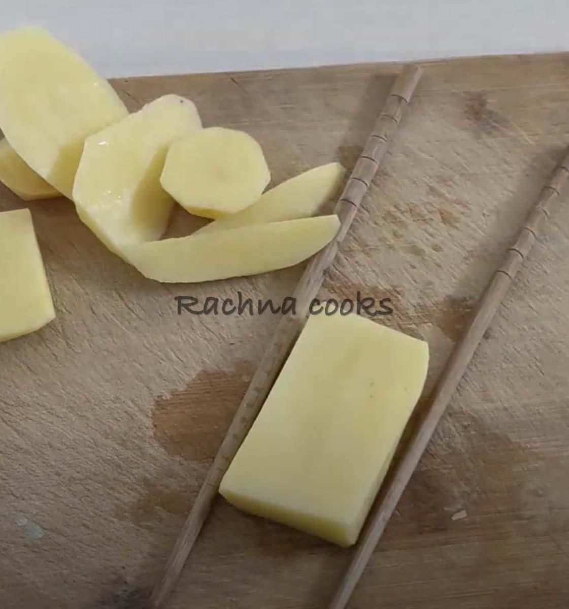 Potato slice kept between chopsticks.