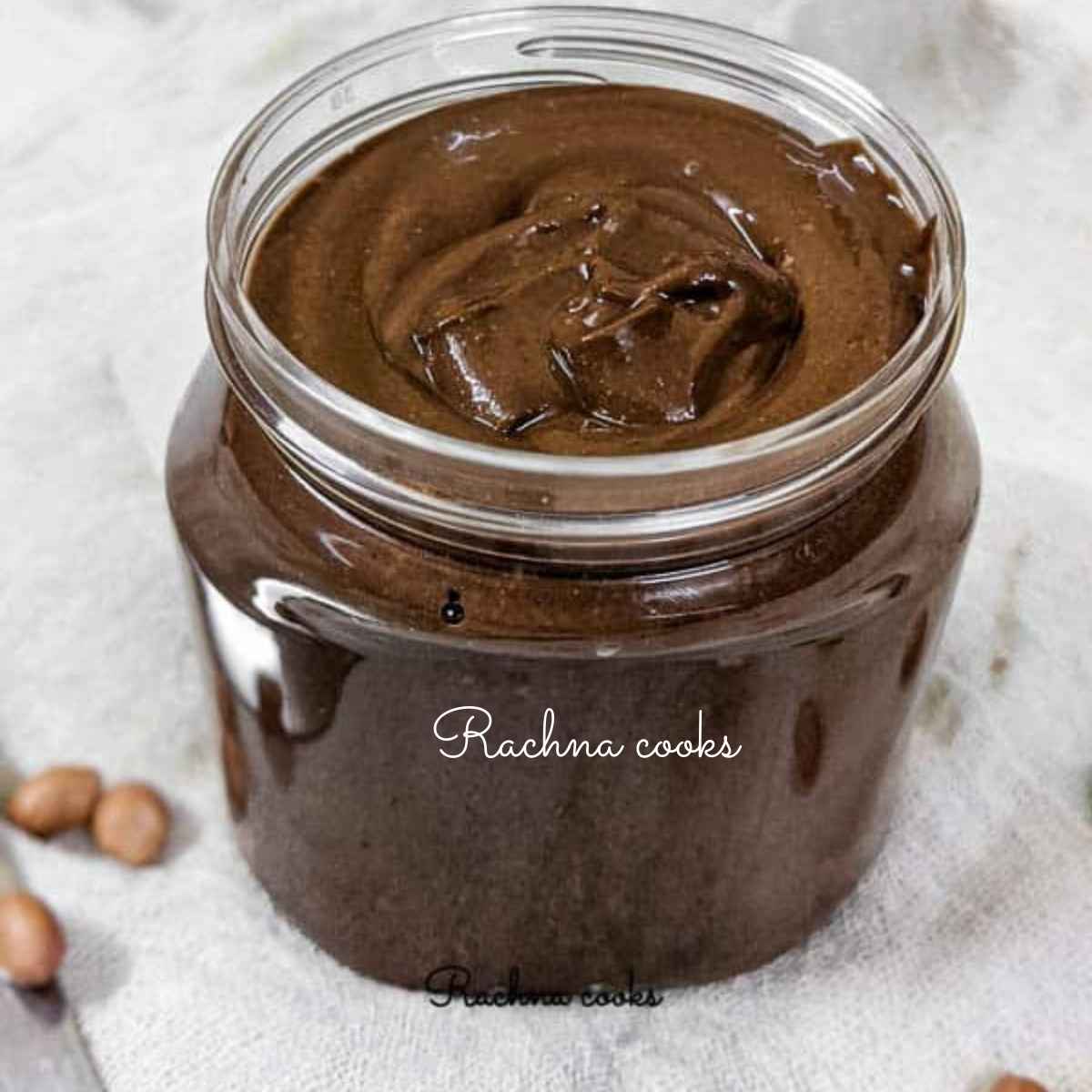 a jar of brown shiny chocolate peanut butter on a white background