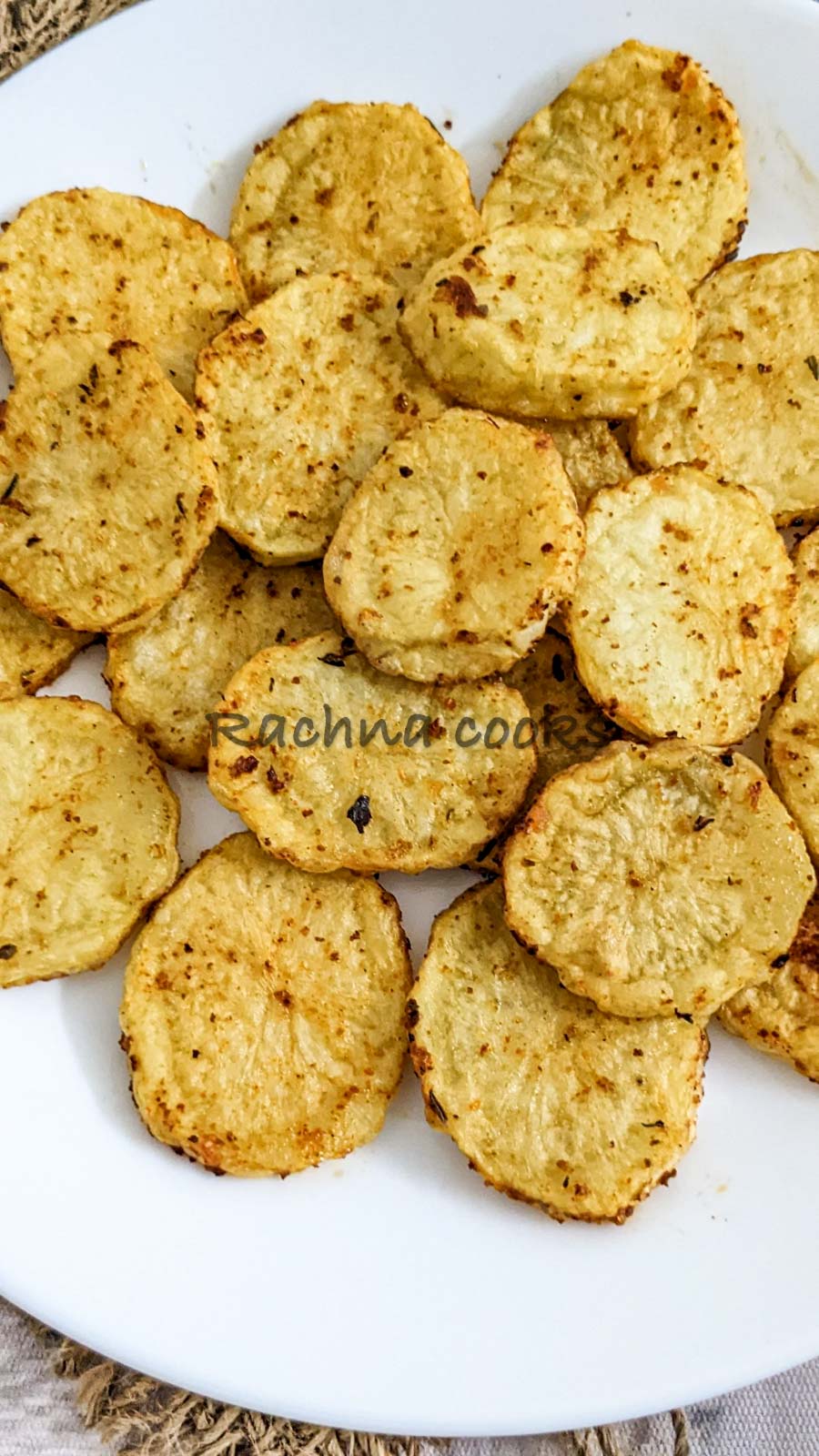 close up of Air fried potato slices on a white plate.
