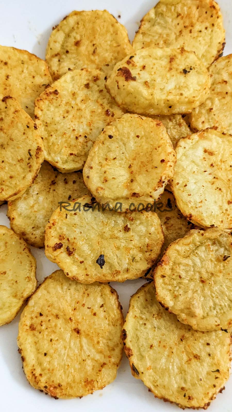 Close up of Air fried potato slices on a white plate.