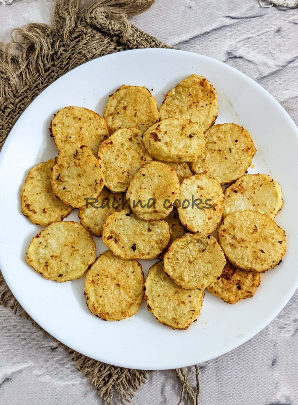 Air fried potato slices on a white plate.