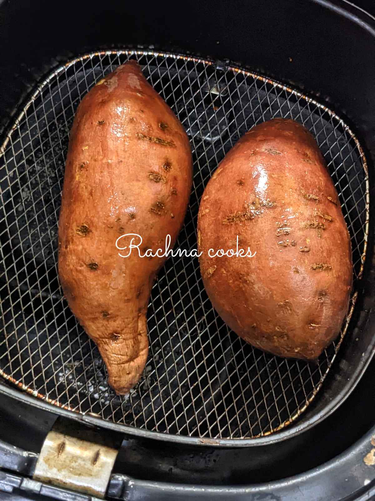 2 sweet potatoes rubbed with olive oil and salt placed in air fryer basket 